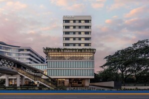Un hôtel à plusieurs étages au design moderne, doté d’un toit plat et de grandes fenêtres.