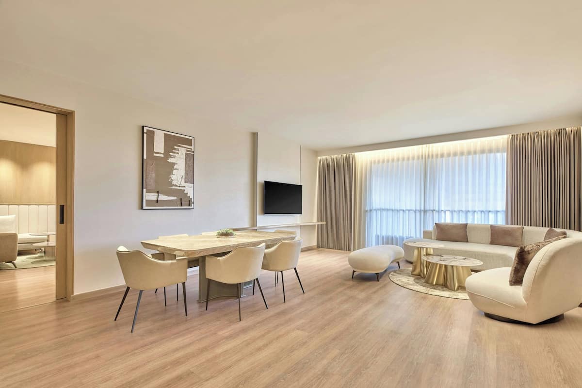 A modern living room with a dining area, a sofa, and a TV.
