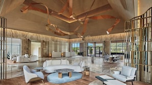 A spacious, modern interior with a wooden ceiling, large seating area, and large windows offering views of the outdoors. - The Westin Jaipur Kant Kalwar Resort And Spa (Amer)