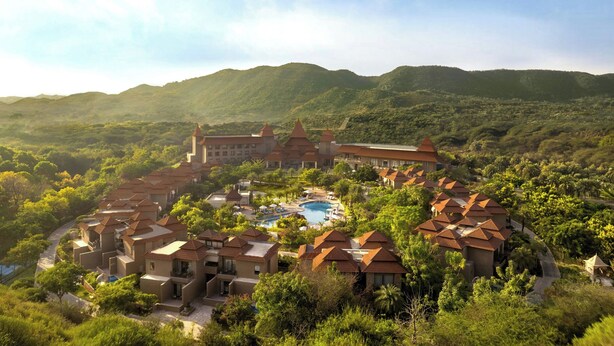 A resort with multiple buildings, a swimming pool, and a mountainous backdrop. - The Westin Jaipur Kant Kalwar Resort And Spa (Amer)