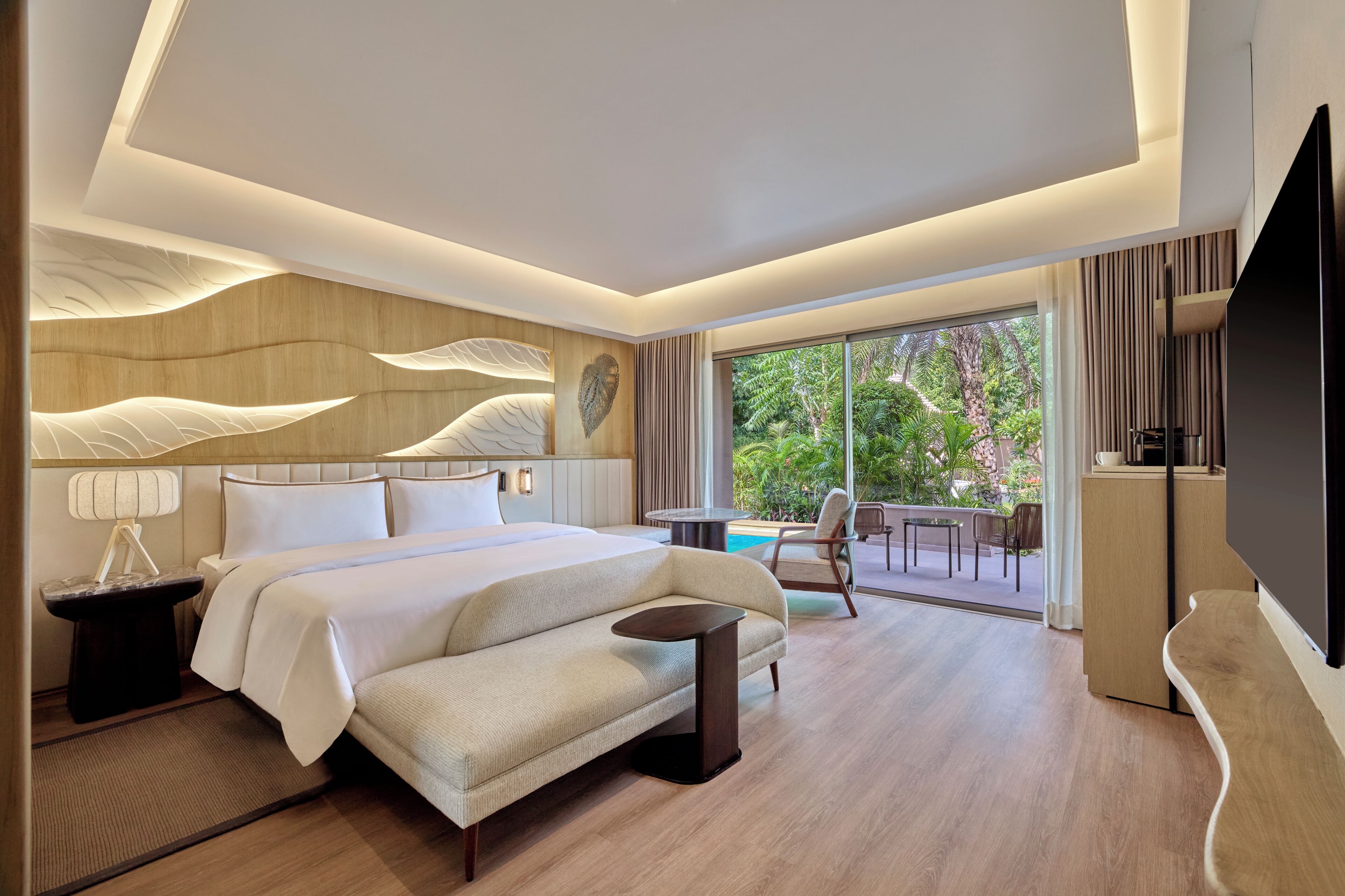 Ein modernes Hotelzimmer mit einem großen Bett, einem Flachbildfernseher, einem Essbereich mit Blick auf einen Pool und einem Balkon.