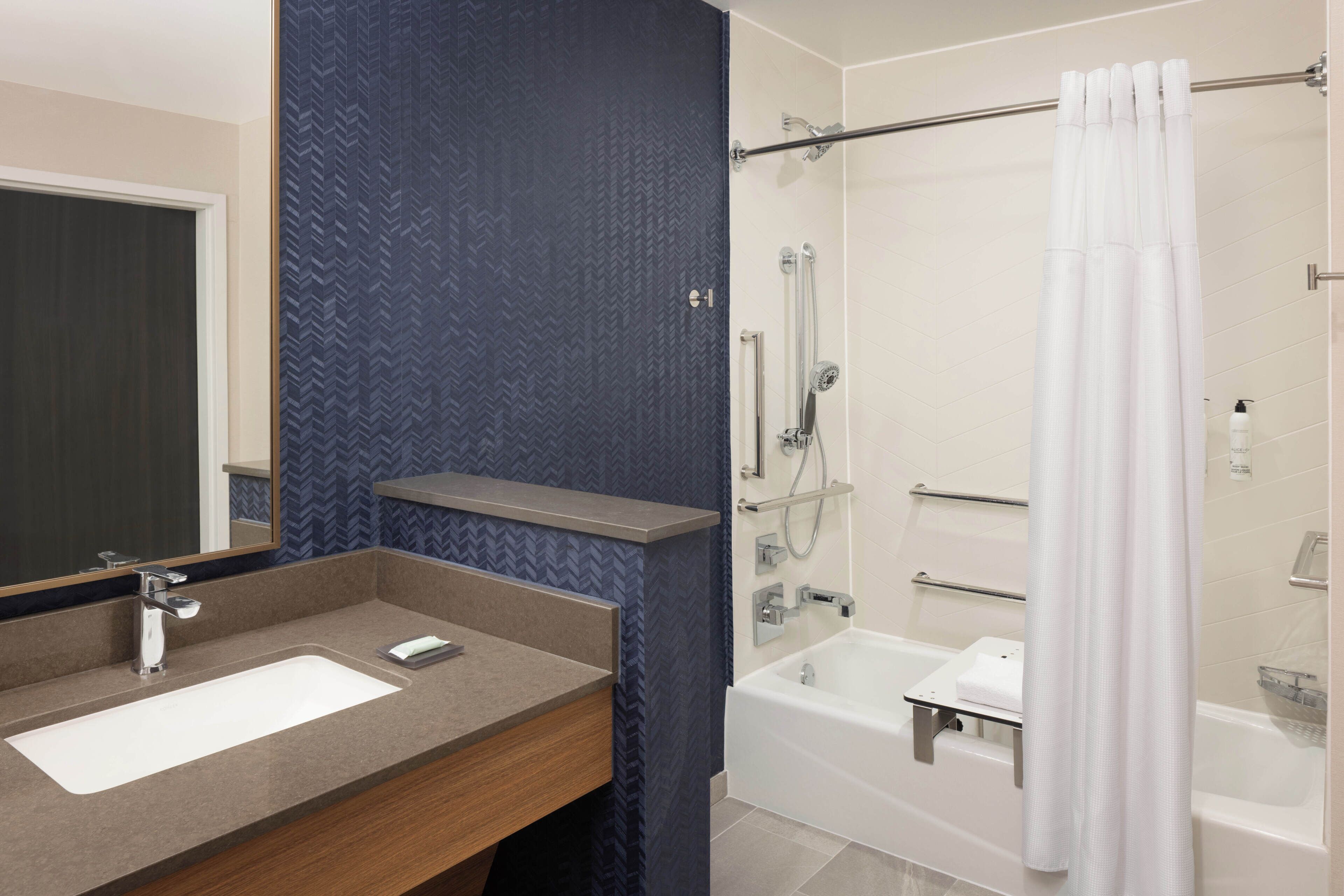 A modern bathroom with a shower, a bathtub, and a vanity with a mirror.