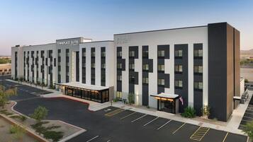A modern hotel with a parking lot and a covered entrance.