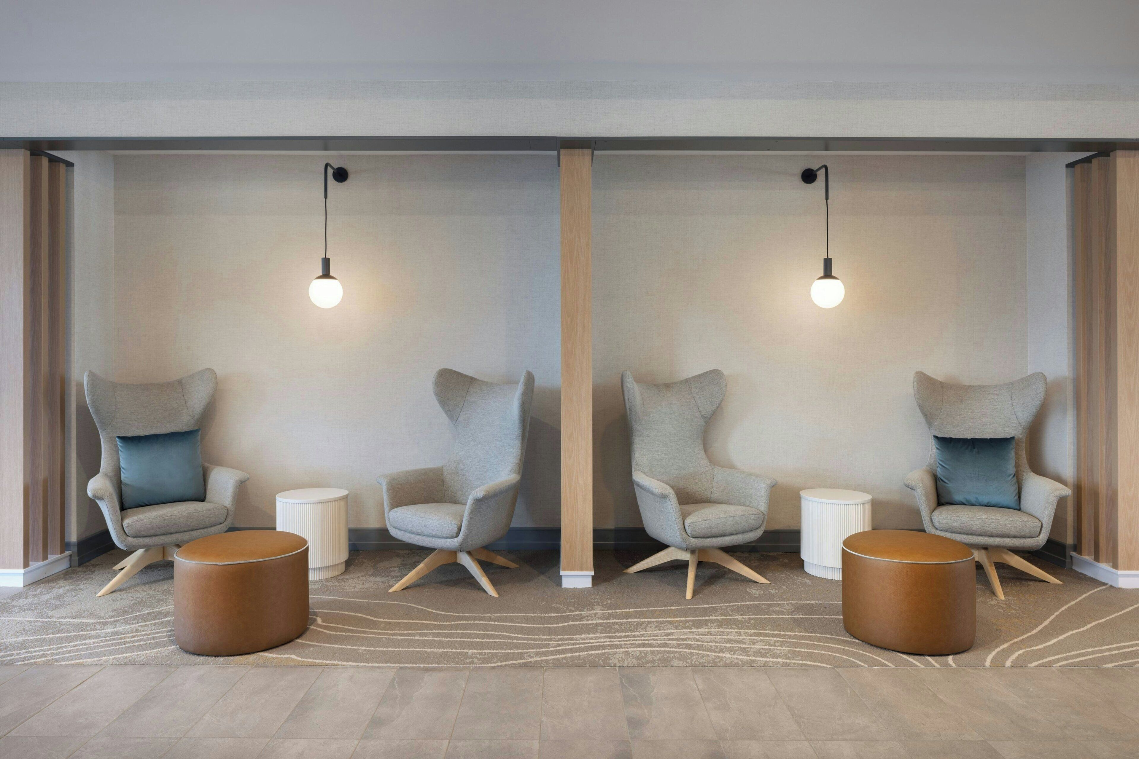 Une pièce moderne avec deux fauteuils, une petite table d’appoint et une table ronde en bois.