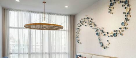 A modern living room with a sofa, armchair, and round side tables.