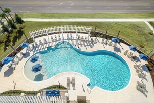 Una piscina al aire libre, sombrillas, sillones reclinables de piscina