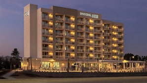 Un hôtel à plusieurs étages doté de balcons, d’un espace extérieur couvert et d’une enseigne indiquant « Springhill Suites ».