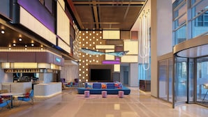 A spacious lobby with a seating area, a reception desk, and a large TV screen. - Aloft Shanghai Hongqiao (Shanghai)