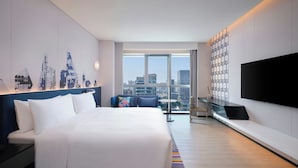A modern hotel room with a large bed, a TV, a city view, and a patterned wall. - Aloft Shanghai Hongqiao (Shanghai)