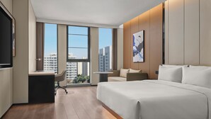 A modern hotel room with a large bed, a desk, and a view of the cityscape through large windows. - Fairfield By Marriott Shanghai Qingpu (Shanghai)