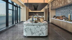A modern kitchen with a marble island, large windows, and a view of the city. - Fairfield By Marriott Shanghai Qingpu (Shanghai)