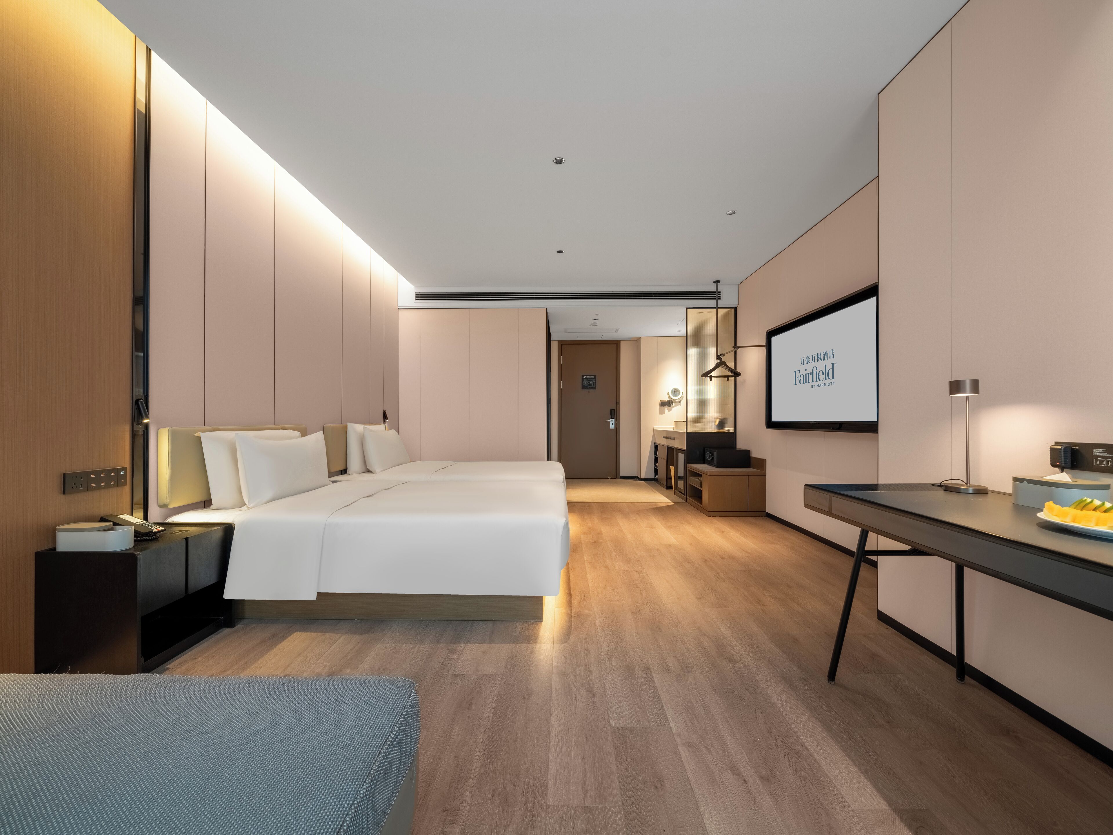 Quarto de hotel moderno com uma cama grande, uma mesa de escritório e um espaço de estar.