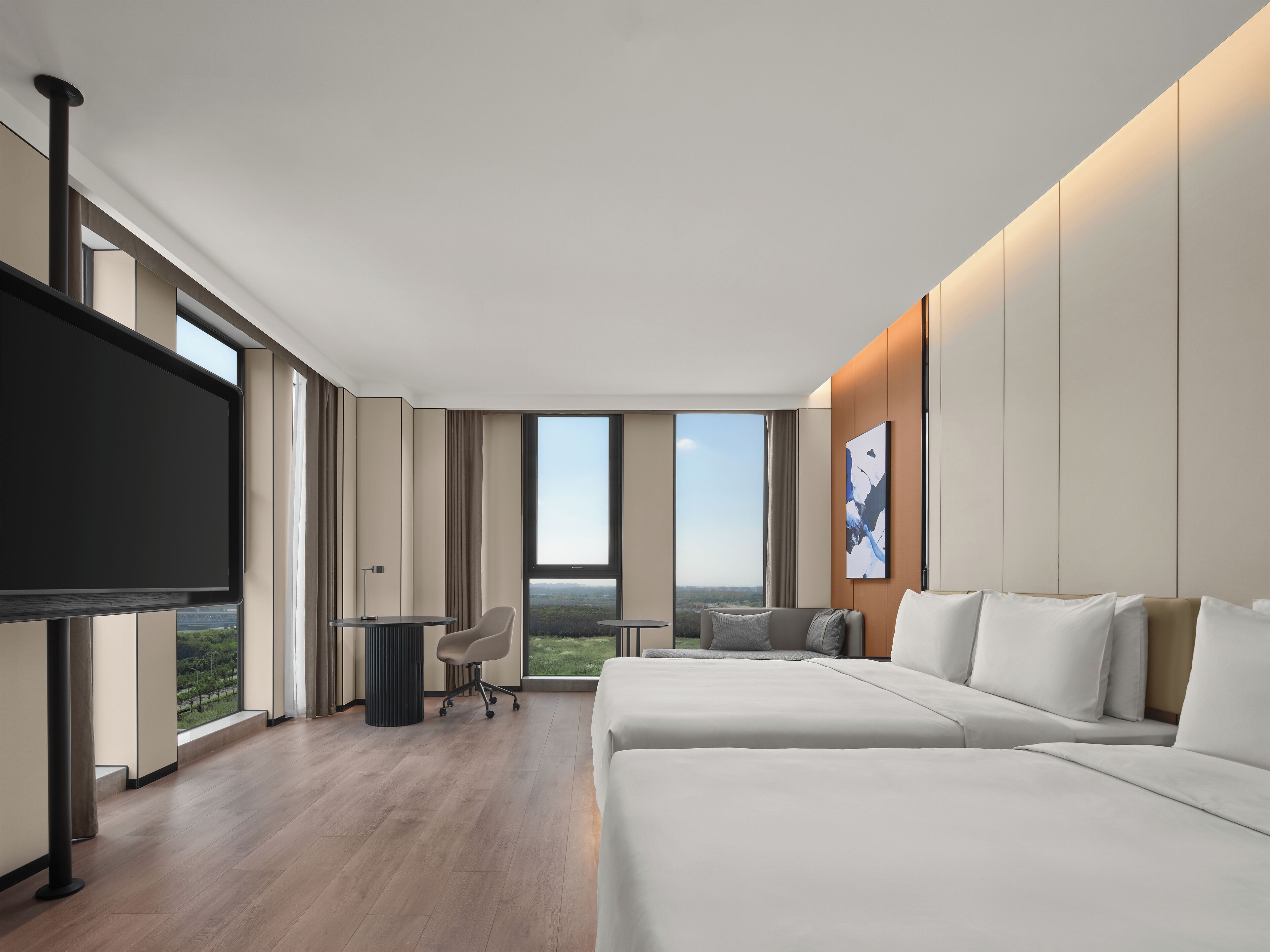 Una habitación de hotel moderna con una cama grande, un escritorio, una silla y un televisor.
