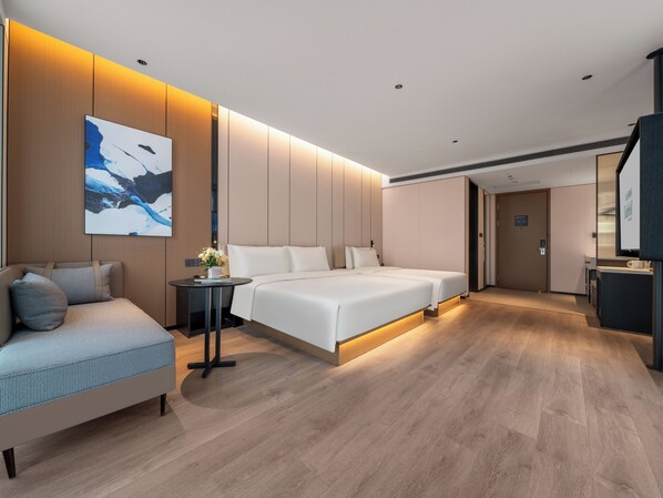 A modern hotel room with a large bed, a sofa, a small table with a vase of flowers, and a painting on the wall. - Fairfield By Marriott Shanghai Qingpu (Shanghai)