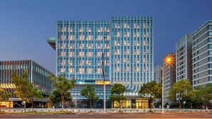 A modern hotel with a grid-like facade, multiple floors, and a prominent entrance. - Fairfield By Marriott Shanghai Qingpu (Shanghai)