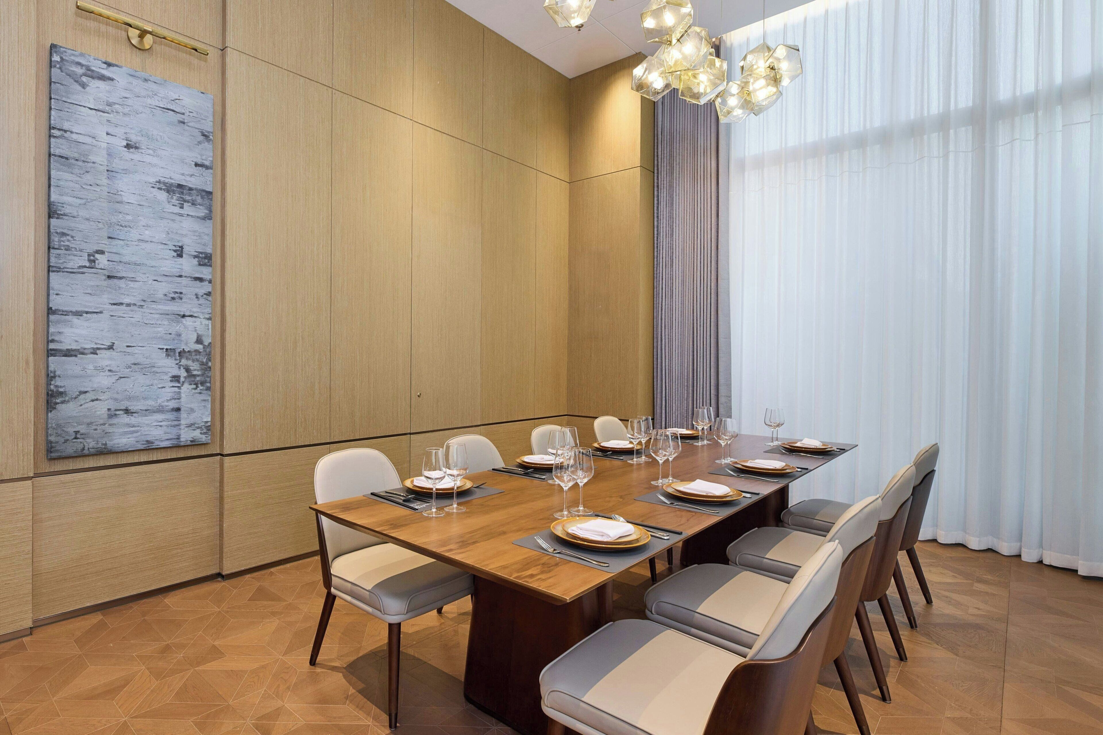 A conference room with a long table, chairs, and a large abstract painting on the wall.