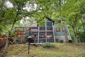 A cabin with a wooden deck, large windows, and a stone foundation. - Starling Hollow • Hot Tub | Fire Pit | Family Vibe (Blue Ridge)