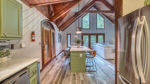 A spacious kitchen with a wooden ceiling, a large island, and a built-in refrigerator. - Starling Hollow • Hot Tub | Fire Pit | Family Vibe (Blue Ridge)