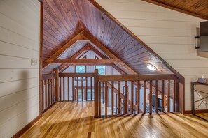 A wooden attic room with a sloped ceiling, wooden beams, and a view through a window. - Starling Hollow • Hot Tub | Fire Pit | Family Vibe (Blue Ridge)