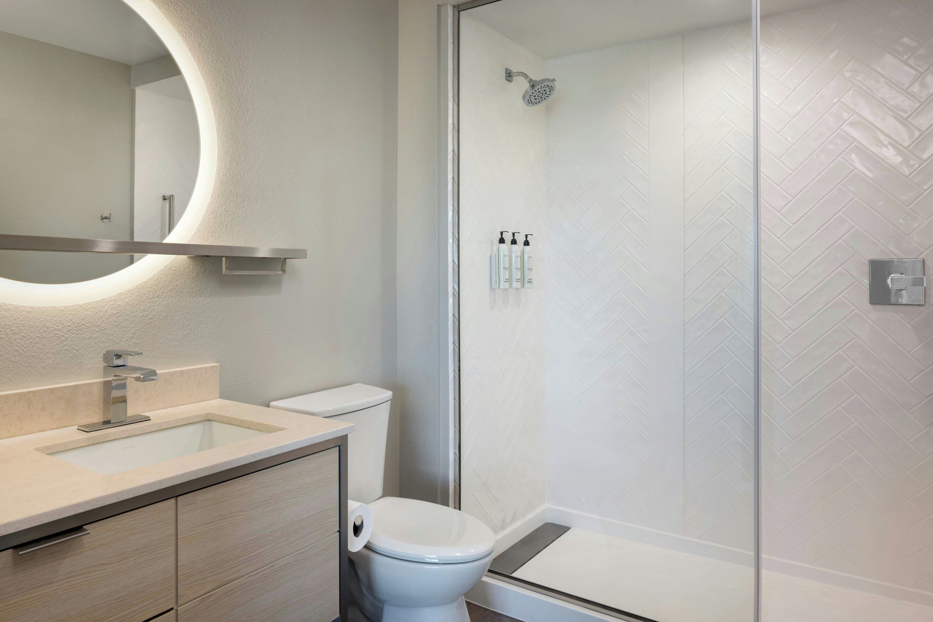 Un baño moderno con inodoro, lavamanos y ducha.