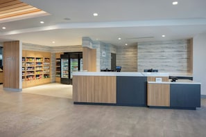 A modern reception desk with a digital display, a refrigerated beverage area, and a snack shelf. - Towneplace Suites By Marriott Casa Grande (Casa Grande)