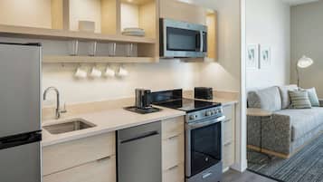 A modern kitchen with a built-in microwave, oven, and coffee maker.