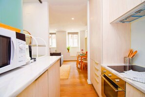 Eine moderne Küche mit Mikrowelle, Backofen und einer Essecke mit Tisch und Stühlen.