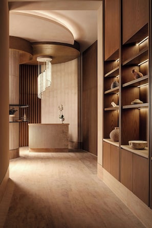 A modern interior with a curved reception desk, wooden shelving, and a hanging light fixture. - The St. Regis Costa Mujeres Resort, Cancun​ (Cancun)