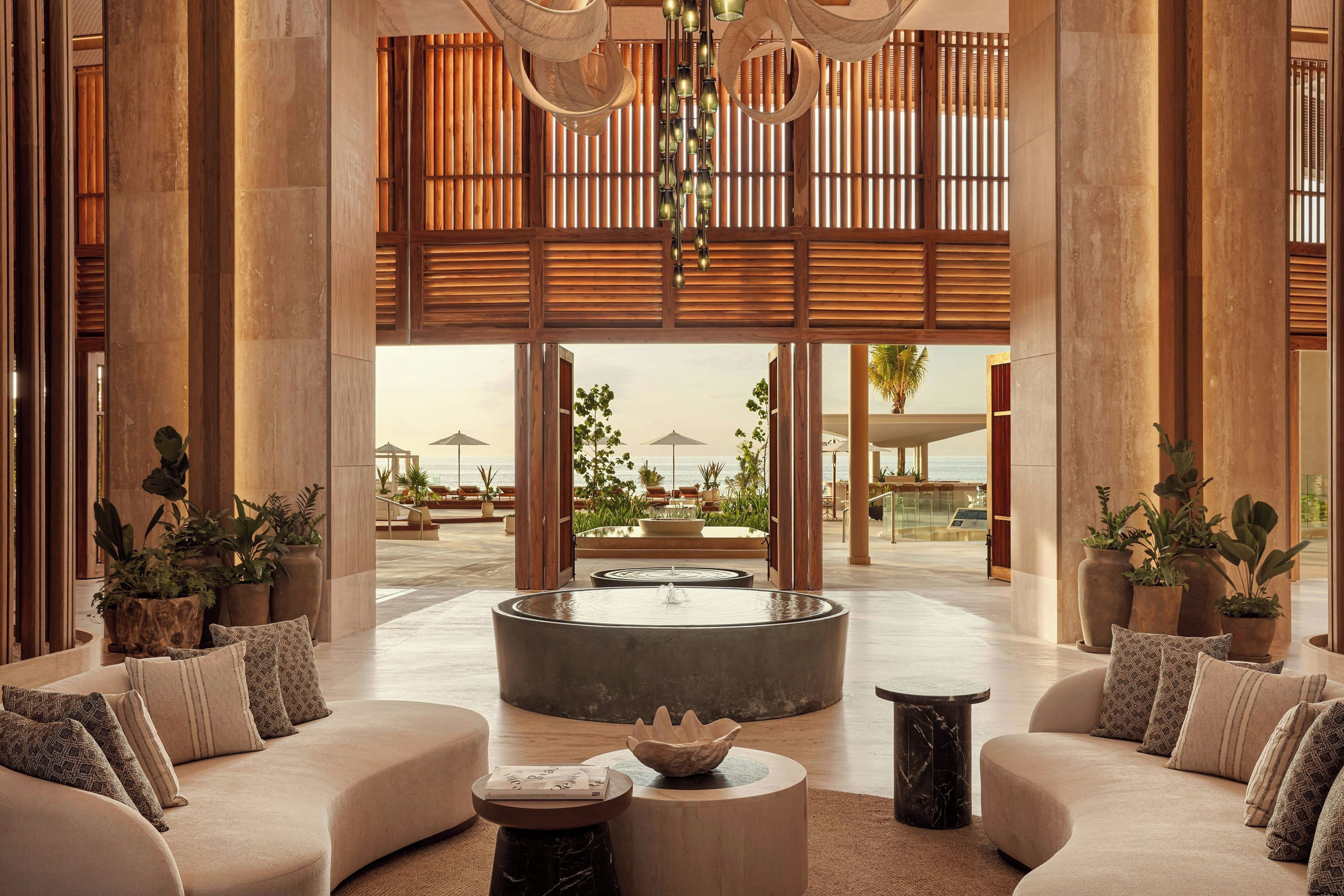 A spacious lobby with a central seating area, large windows, and a view of the ocean.