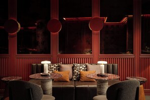A dimly lit room with a leather sofa, two round tables with lamps, and a patterned wall. - The St. Regis Costa Mujeres Resort, Cancun​ (Cancun)