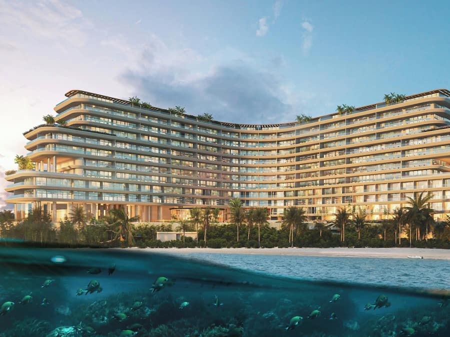 A multi-story hotel with a curved facade, balconies, and a pool area with underwater views.