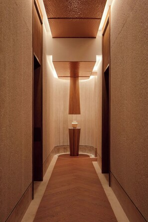 A corridor with a wooden floor, a central light fixture, and walls with a textured finish. - The St. Regis Costa Mujeres Resort, Cancun (Cancun)