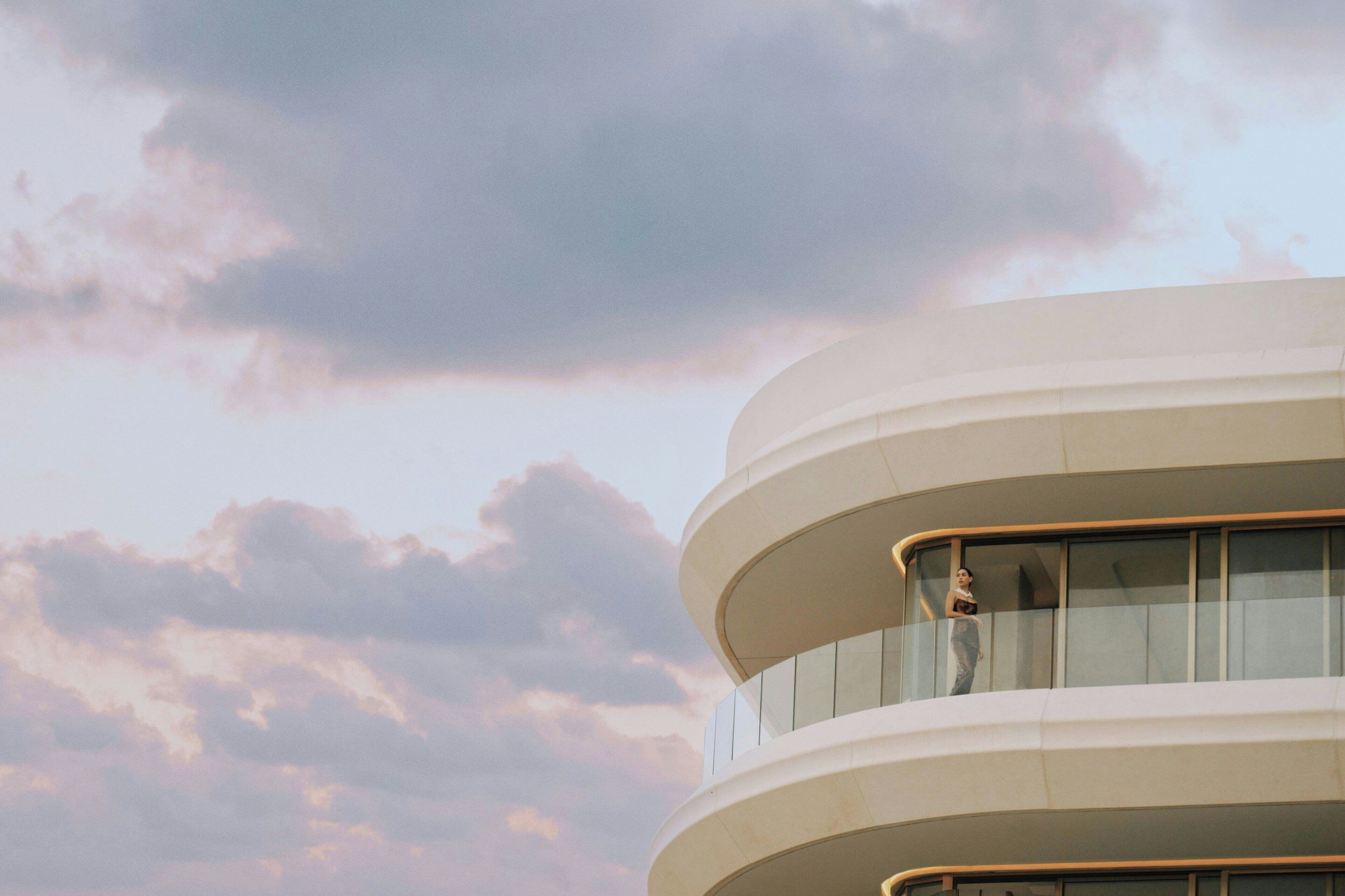 Un edificio de varios niveles con fachada curva y grandes ventanales.