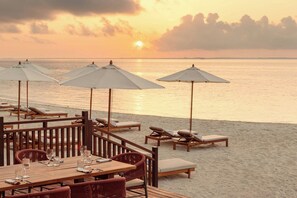 A beachside restaurant with outdoor seating, umbrellas, and a view of the sea. - The St. Regis Costa Mujeres Resort, Cancun​ (Cancun)