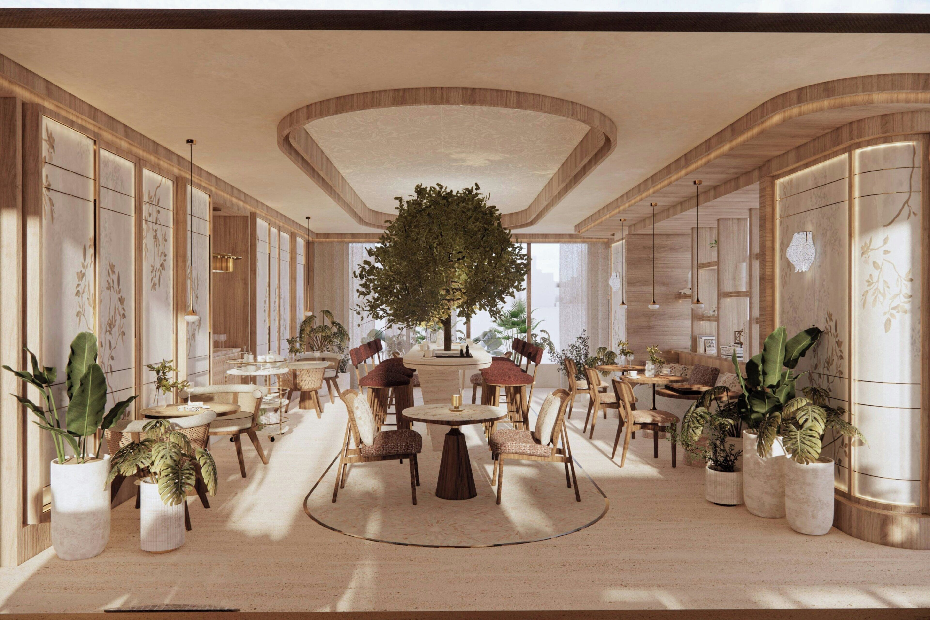A spacious lobby with a central round table, surrounded by seating, and a large tree.