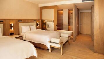 Une chambre d’hôtel avec un grand lit, des tables de chevet, une chaise, un ventilateur de plafond et un plancher en bois.