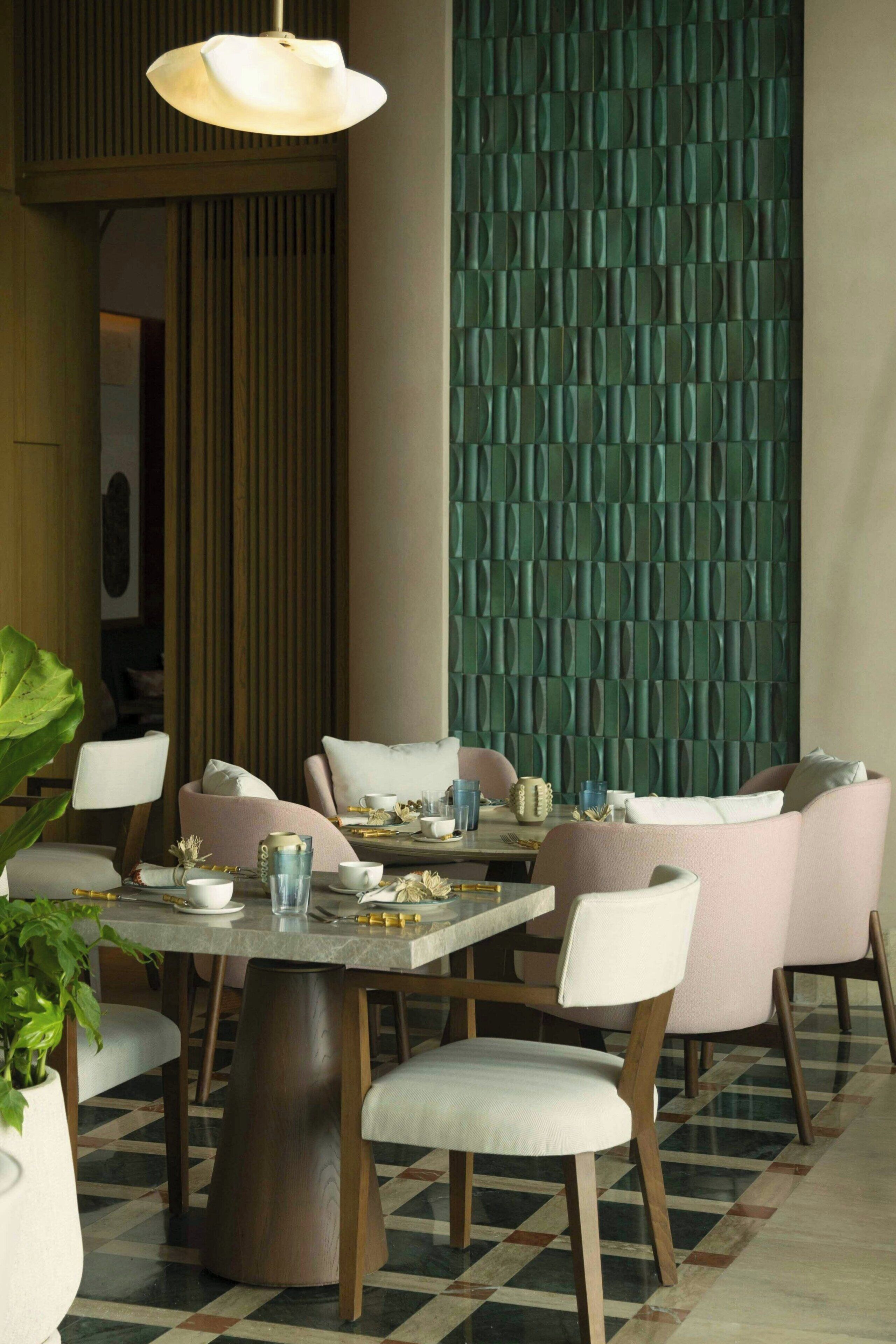 Un comedor con una mesa dispuesta para cuatro, rodeada de sillas, y un papel tapiz decorativo en el fondo.