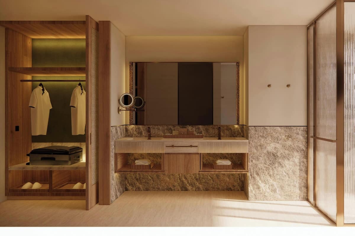 A modern bathroom with a wooden vanity, a large mirror, and a built-in shelf with towels.