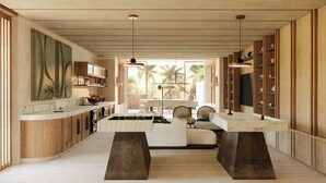 Una cocina moderna con una isla central, armarios de madera y vistas a palmeras.