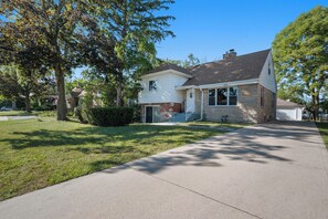A two-story house with a front porch, a garage, and a well-maintained lawn. - Unique Home in Maywood - 5 Bedroom (Maywood)