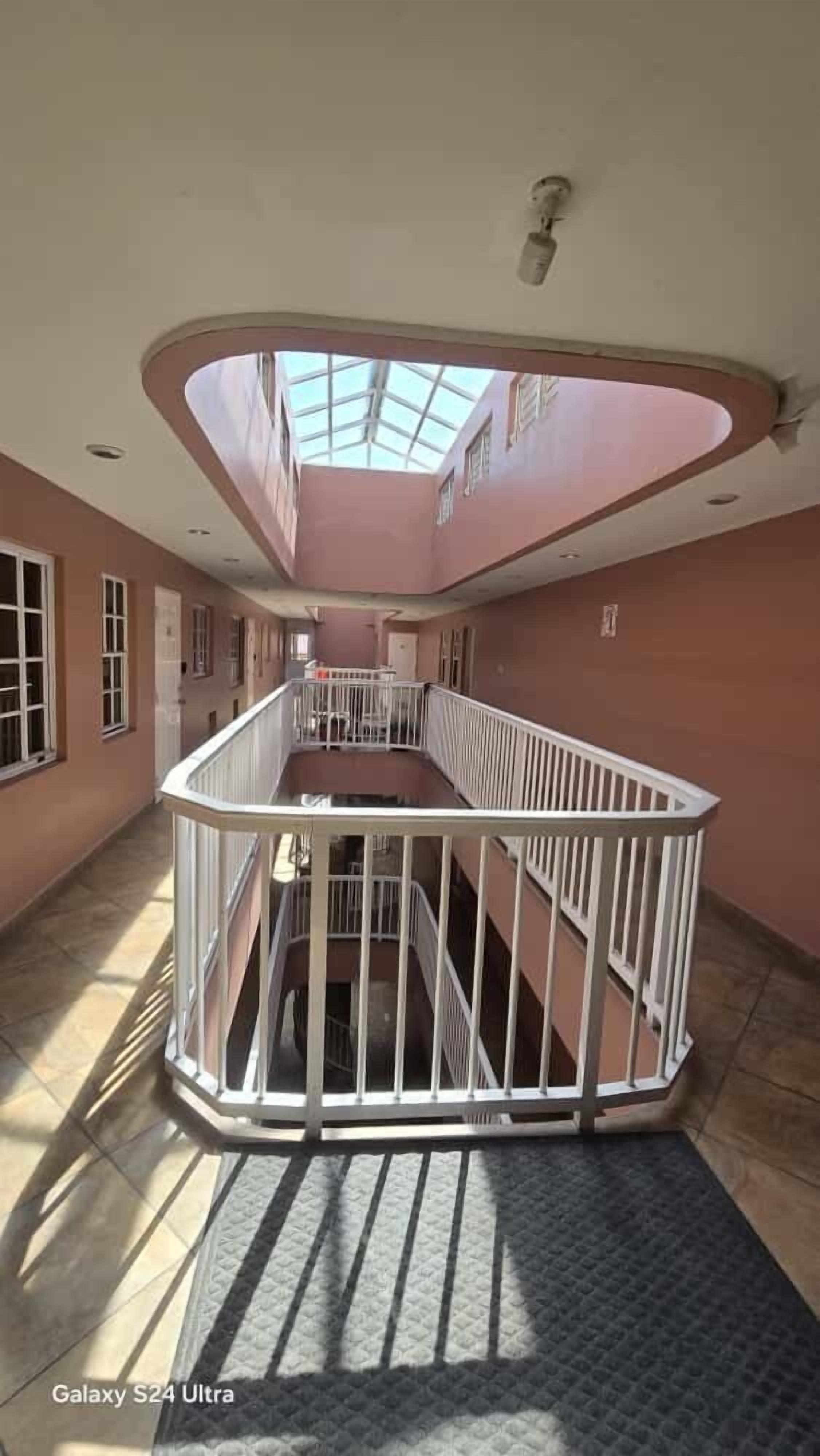 Een ruim interieur met een centraal atrium, een trap en een dakraam.