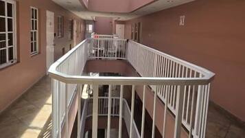 Een ruim interieur met een centraal atrium, een trap en een dakraam.