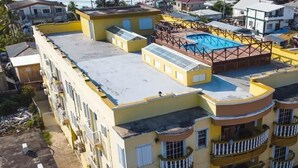 A multi-story building with a rooftop pool, balconies, and a flat roof. - Paradise Suites & Residence  (San Pedro)