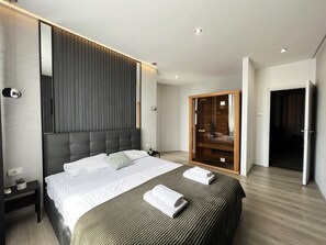 Een moderne hotelkamer met een groot bed, een garderobe en een klein nachtkastje.