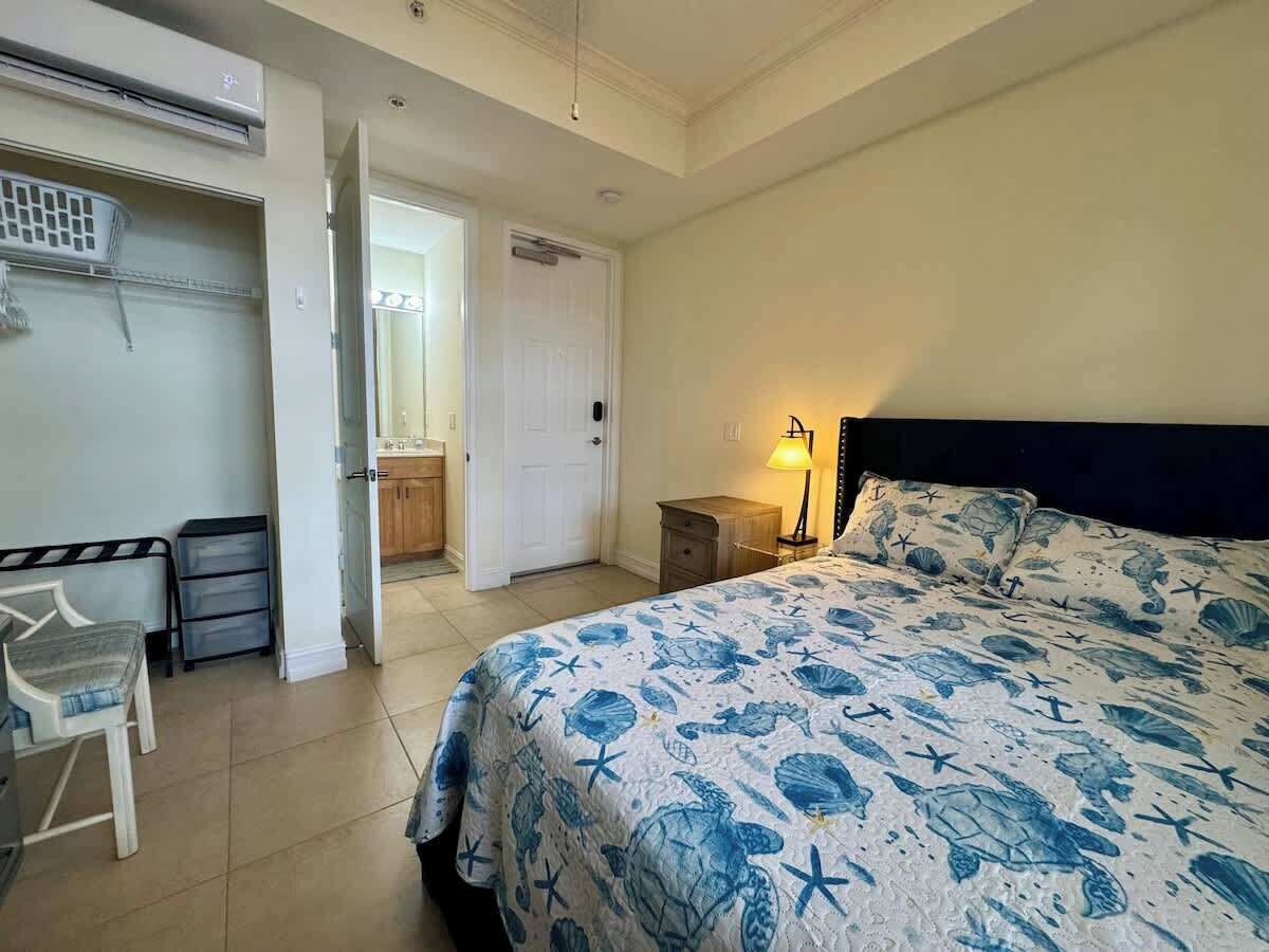 A bedroom with a bed, a desk, and a chair.