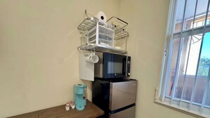 A compact kitchen with a microwave, refrigerator, and a window. - Bright Studio – Free WiFi – Bonita Springs (Bonita Springs)