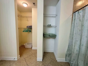 A bathroom with a shower curtain, a towel rack, and a laundry basket. - Modern Retreat – Beach Gear – Near the Sand (Bonita Springs)