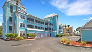 A multi-story hotel with a blue exterior, multiple balconies, and a parking area. - Sunlit Getaway – Free WiFi – 1 Mi to the Gulf (Bonita Springs)