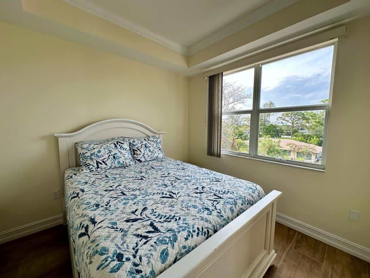 A bedroom with a bed, a window, and a view of the outdoors.