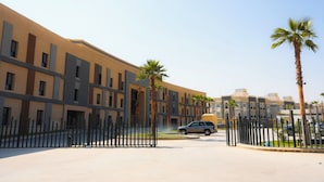 A modern building with a symmetrical facade, multiple windows, and a gated entrance. - 2-bedroom apartment in beautiful Riyadh with Full Facilities (Riyadh)